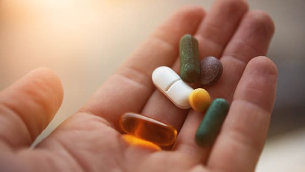 man hand holding his nutritional supplemets, healthy lifestyle background.